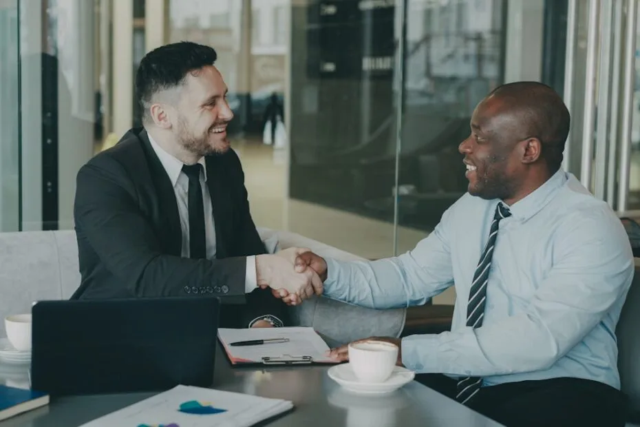 Twee zakenmensen schudden handen bij afspraak over concurrentiebeding en headhunting