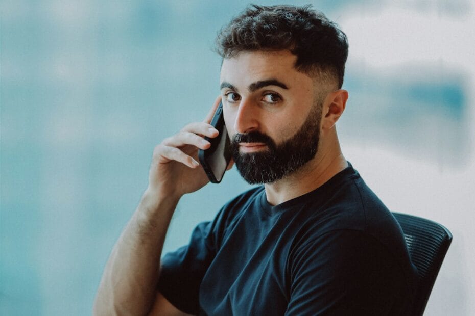 Man met baard belt op kantoor als voorbeeld van mobiel communiceren bij recruitment