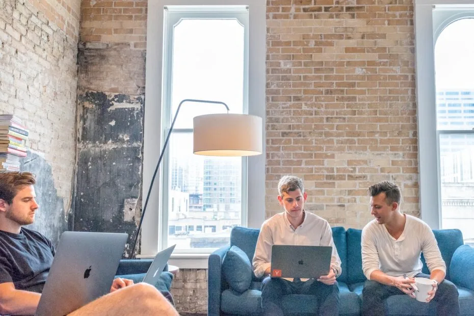 Drie mannen werken op laptops samen voor recruitment strategie