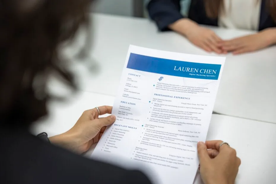 Vrouw leest cv van sollicitant aan tafel tijdens selectieprocedure
