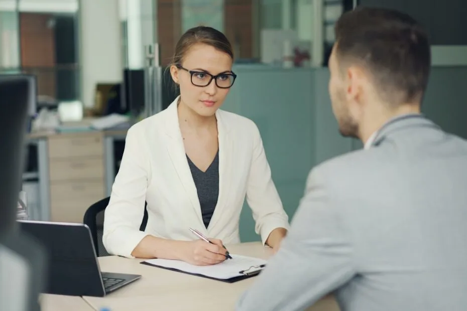 Recruiter stelt sollicitatievragen aan een kandidaat tijdens een gesprek aan een bureau