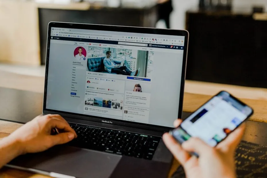 Persoon gebruikt laptop en smartphone voor social media werving en selectie