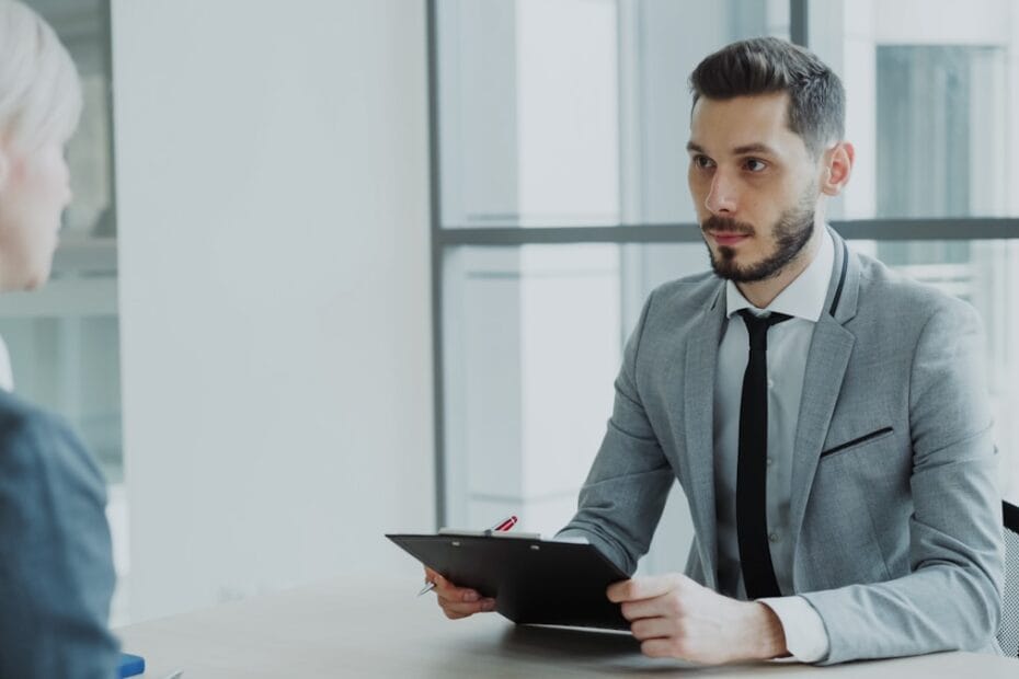 Twee mensen in zakelijk gesprek met klembord bij recruitment interview
