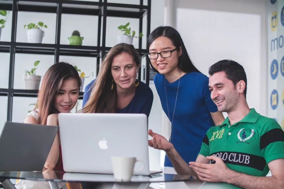 Vier mensen werken samen op laptop voor recruitment project