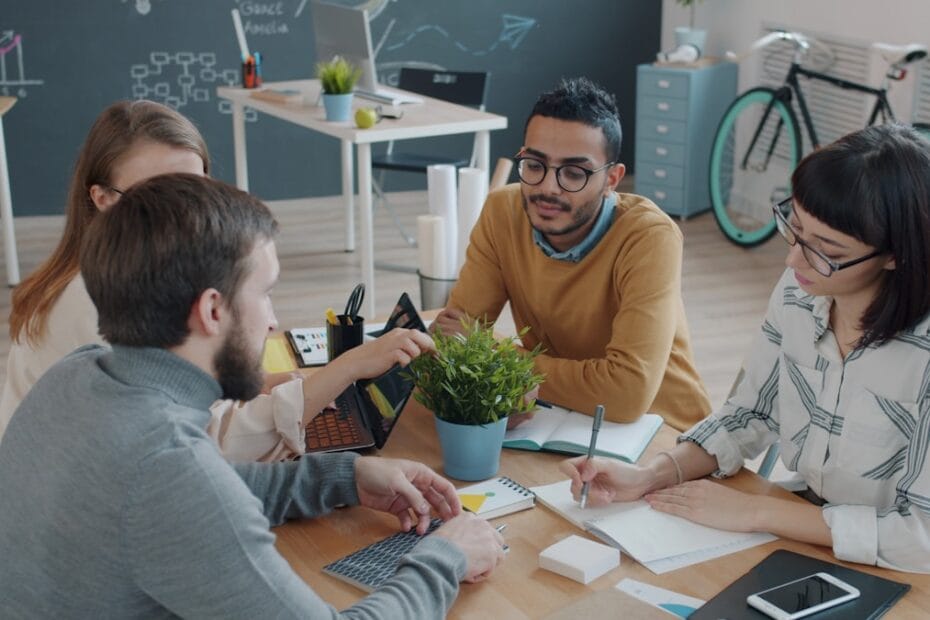 Divers team werkt samen aan tafel op kantoor voor inclusief recruitment