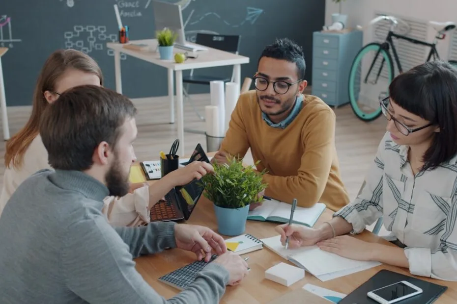 Divers team werkt samen aan tafel op kantoor voor inclusief recruitment